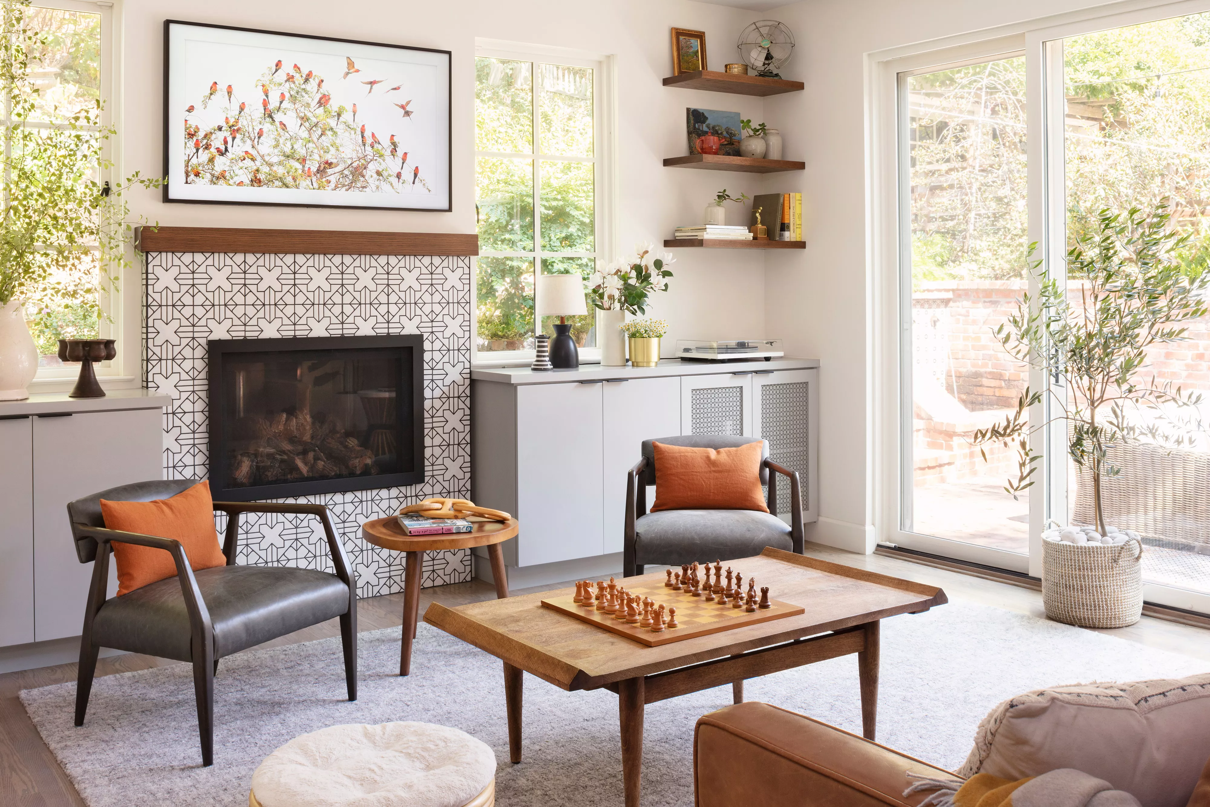 modern living room with tiled fireplace, sliding doors, shelves on walls